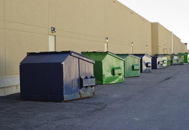 a row of large construction dumpsters on-site in Casnovia